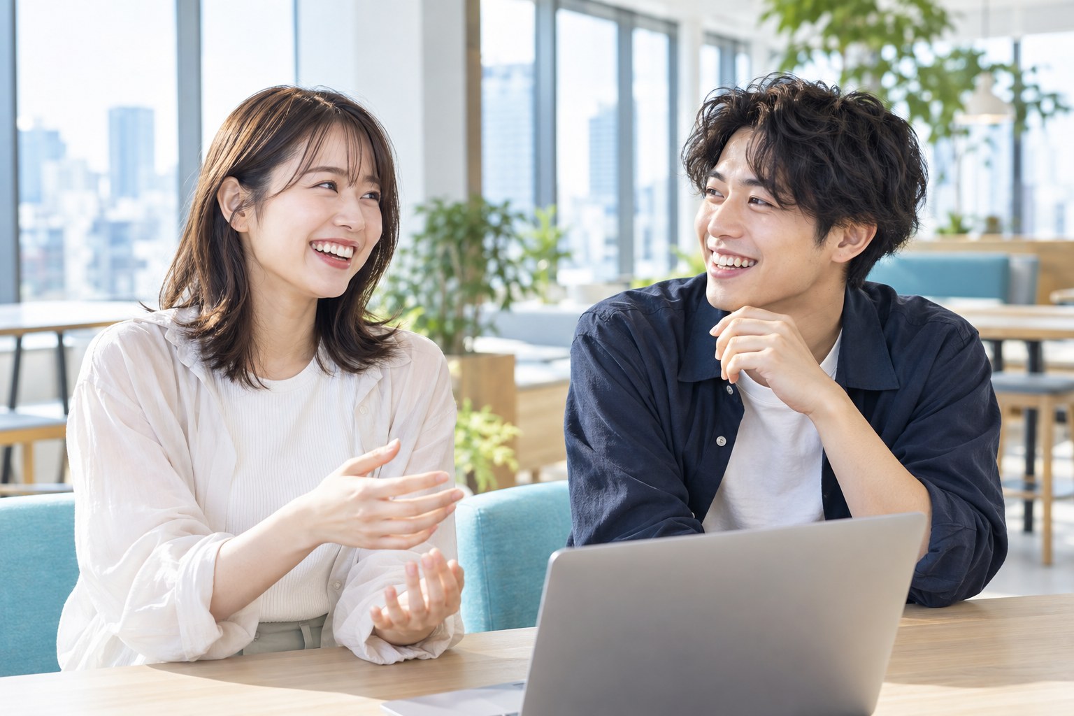 明るいオフィスで笑顔を見せる20代の男女